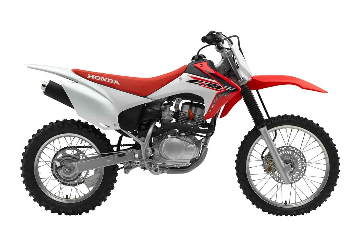 2017 Honda CRF150F dual-sport trail bike in white and red, right-side studio profile showing the spoked wheels and knobby tires