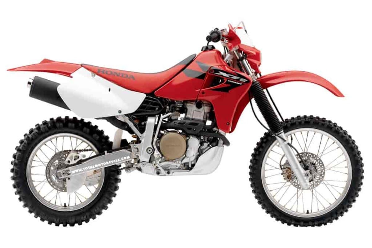 2007 Honda XR650R dual-sport enduro in red with white side panels, right-side studio profile showing the black exhaust canister and spoked wheels
