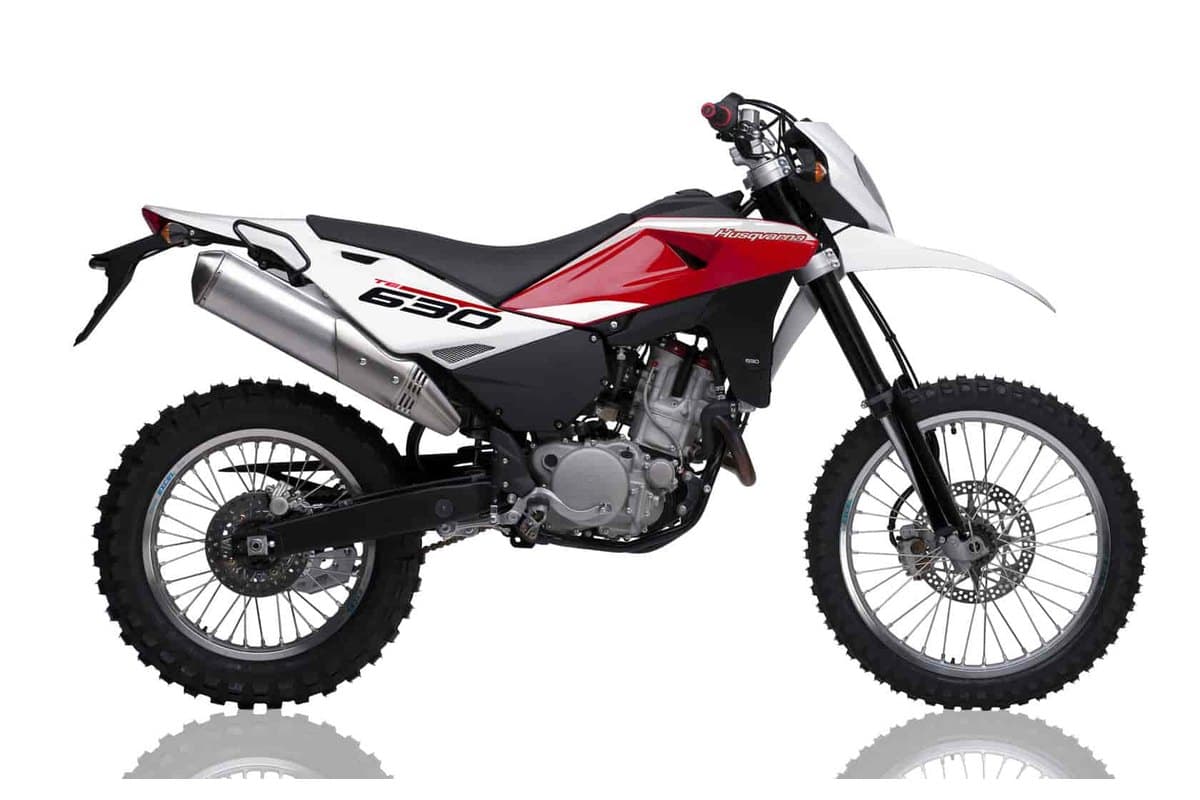 2012 Husqvarna TE630 dual-sport in white, red and black, right-side studio profile with spoked wheels, knobby tires and a high stainless exhaust