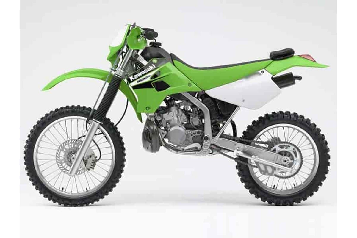 2006 Kawasaki KDX200 dual-purpose enduro in green and white, left-side studio profile showing spoked wheels, disc brakes and dual exhaust silencers