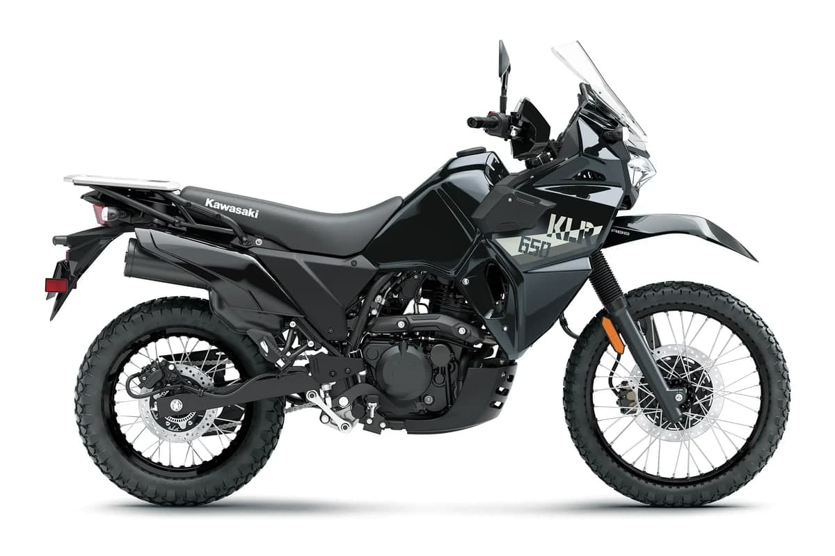 2027 Kawasaki KLR650 in Metallic Spark Black, side studio profile showing the windscreen, rear rack and spoked wheels