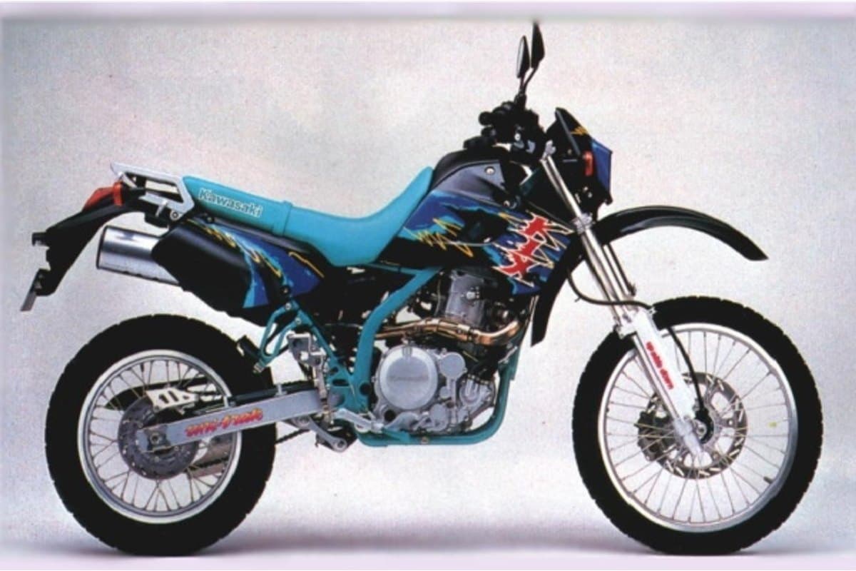 1996 Kawasaki KLX650 dual-sport in teal with black and lightning-bolt graphics, right-side studio profile showing spoked wheels and upswept exhaust
