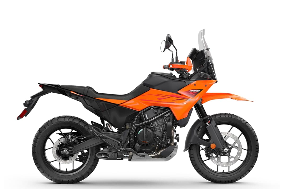 2026 KTM 390 Adventure X in orange, right-side studio profile showing the WP APEX fork, 19-inch front wheel and steel trellis frame