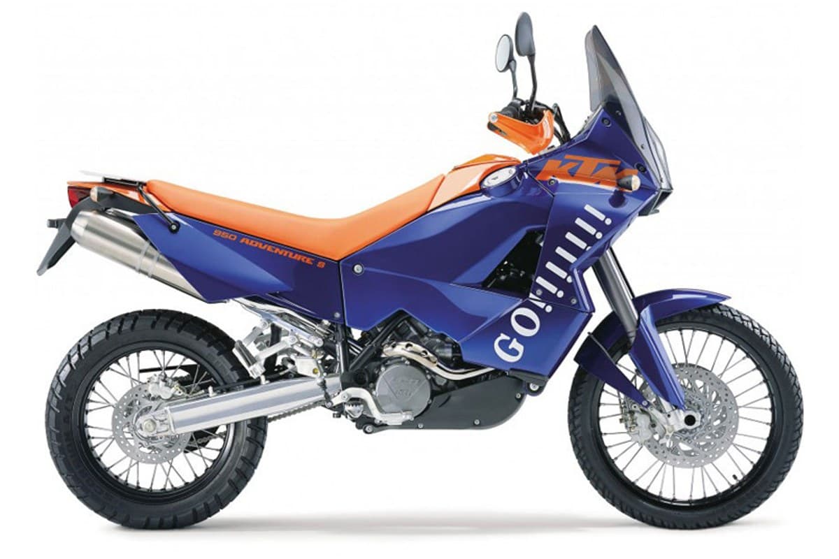 2006 KTM 950 Adventure S in blue and orange, right-side studio profile showing spoked wheels, twin exhaust cans and tall windscreen