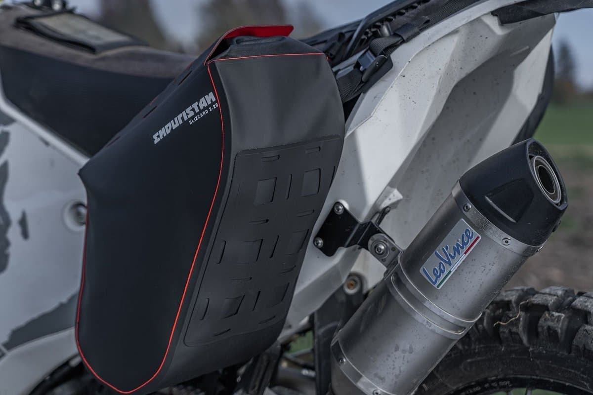 Blizzard 2.25 bag mounted beside the exhaust on a dual sport bike
