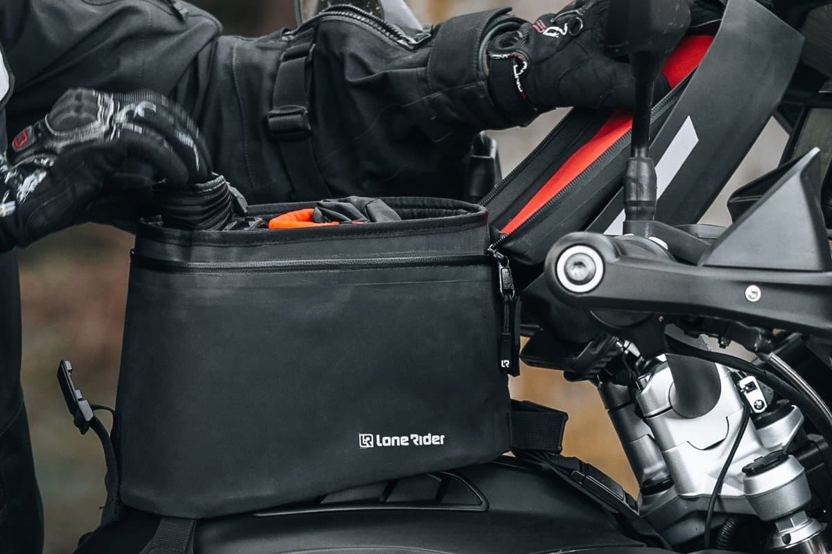 Ranger tank bag mounted on a motorcycle tank, rider reaching in