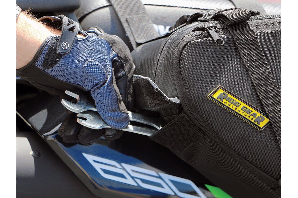 Rider pulling a wrench from the saddlebag's underside tool pouch