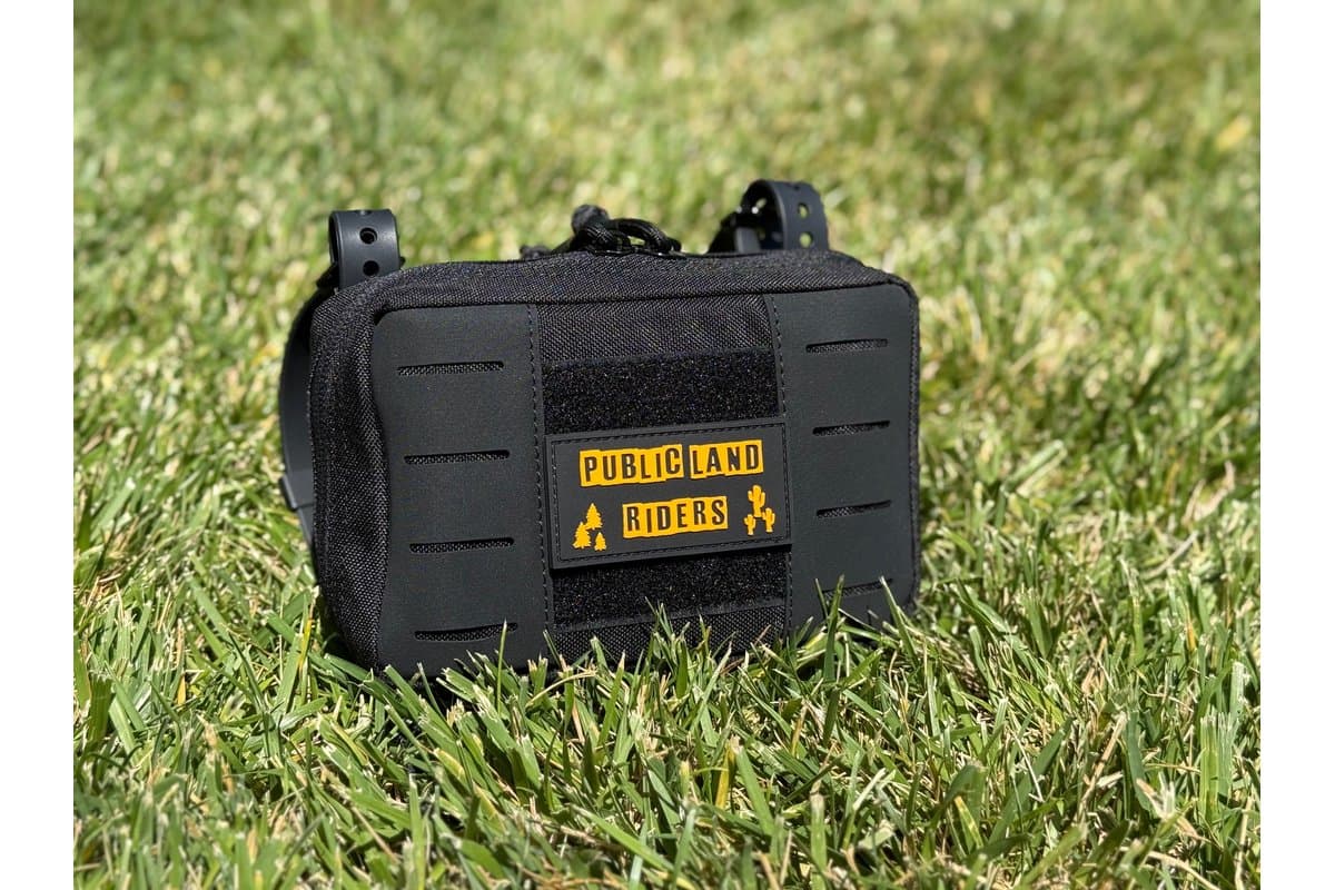 Black Handlebar Tool Bag 2.0 with laser-cut MOLLE front, on grass