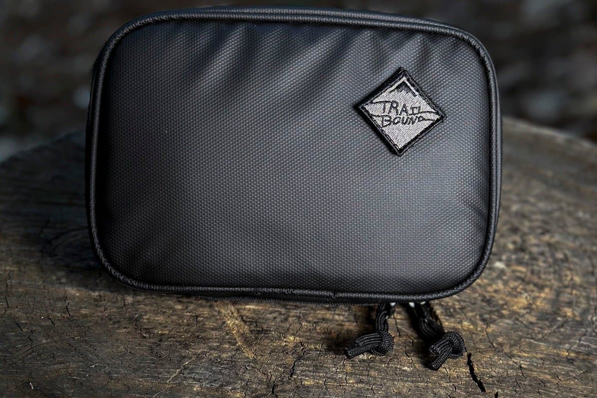 Black Pad Pack Medium Single Pocket on a tree stump