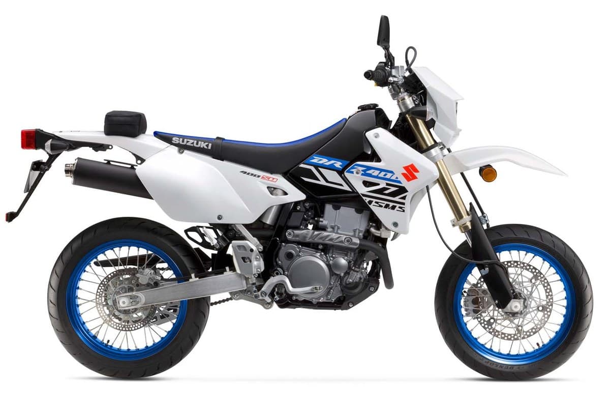 2024 Suzuki DR-Z400SM supermoto in white and black with blue accents, right-side studio profile showing the inverted forks and blue-rimmed wheels