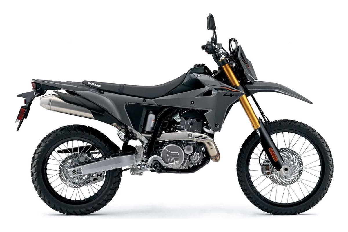 Suzuki DR-Z4S dual-sport motorcycle in matte gray, right-side studio profile with gold-anodized forks and stubby stainless exhaust