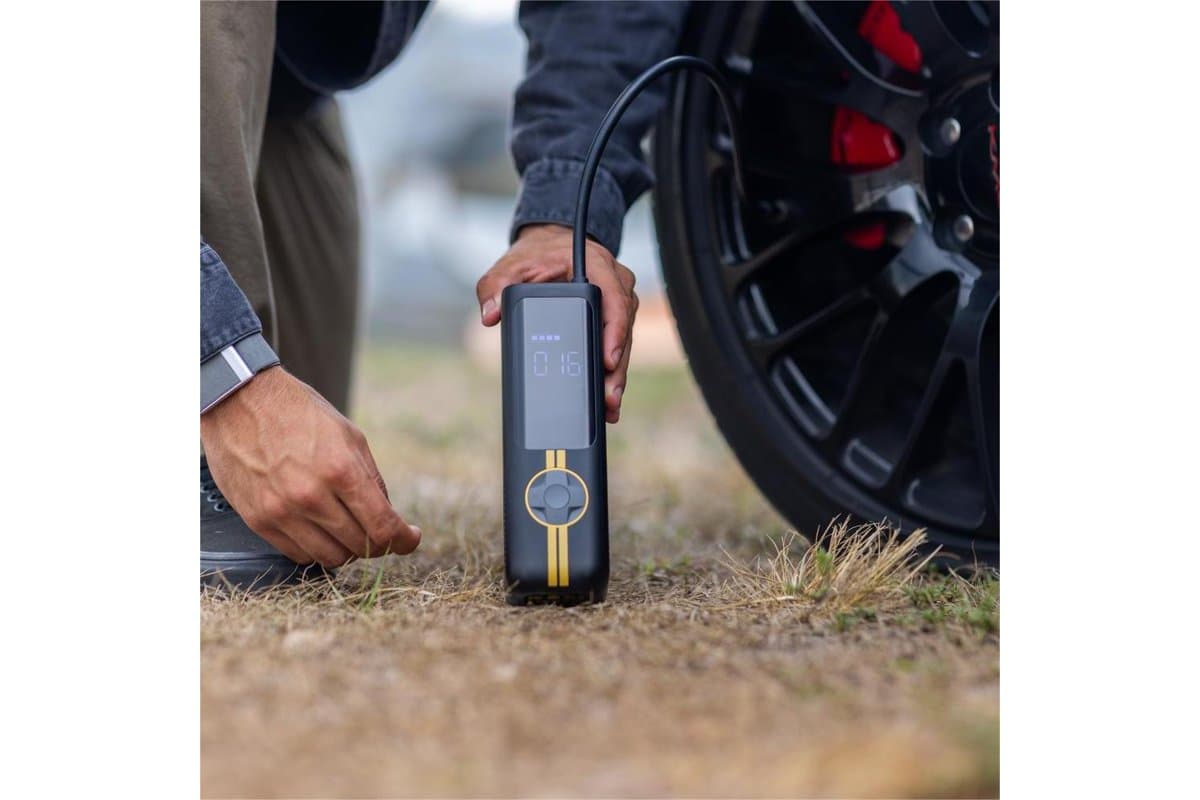 X8 APEX standing on the ground connected to a car tire while its owner crouches beside it