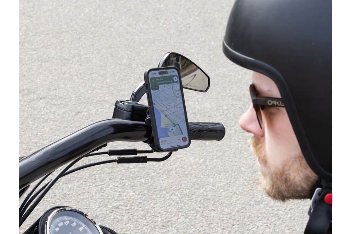Rider looking at a phone held on a Brake/Clutch Mount at the end of a cruiser handlebar