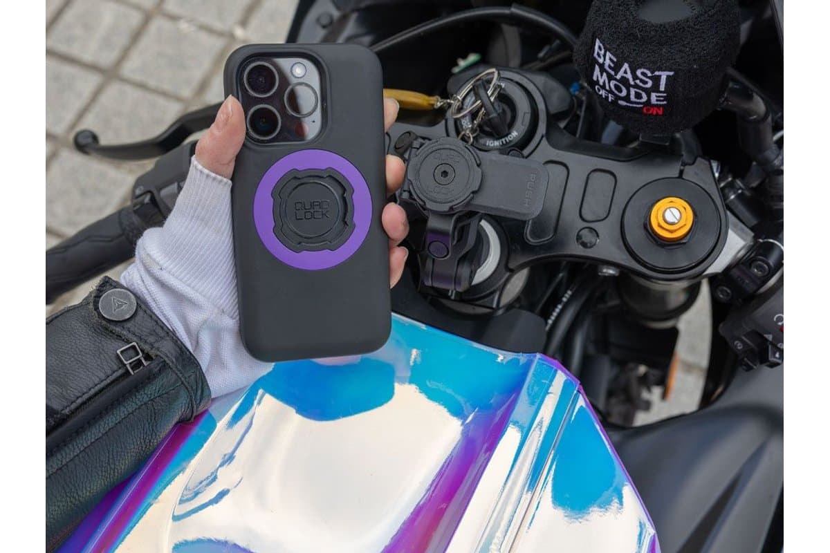 Hand holding a phone in a Quad Lock case above a Fork Stem Mount PRO on a sport bike's top clamp