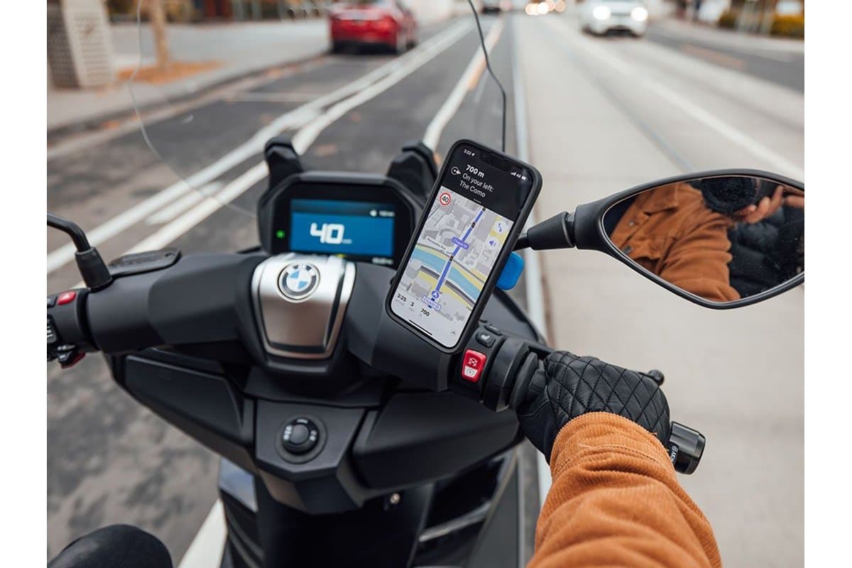 Phone showing navigation on a Quad Lock Mirror Mount beside a scooter's right mirror
