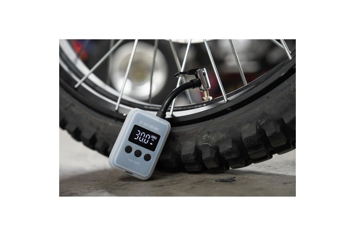 The inflator in its sleeve, connected to a dirt bike's front tire valve