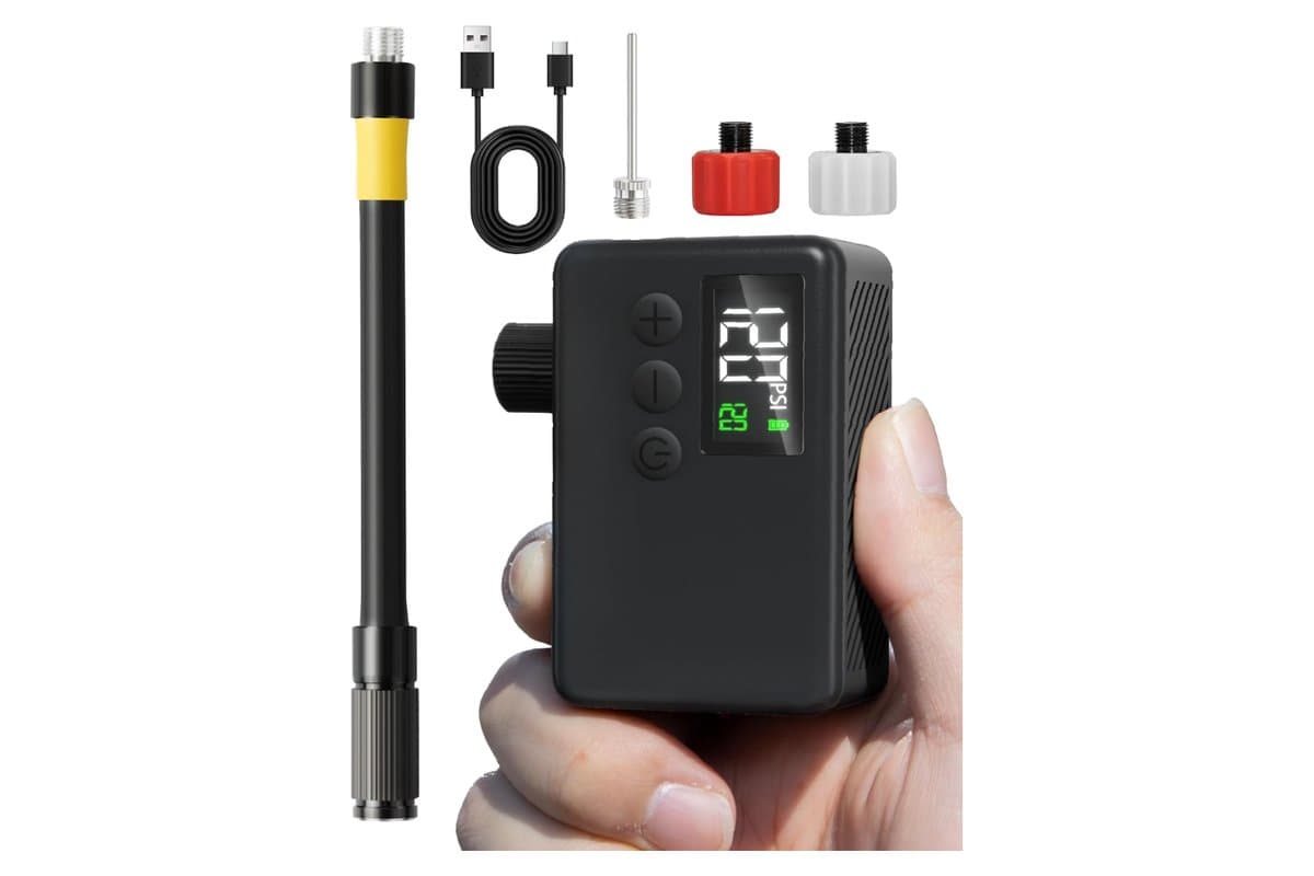 GPUTEK BL01 mini pump held in a hand, its display reading 120 psi, beside the air hose, USB-C charging cable, ball needle and the red and white valve adapters