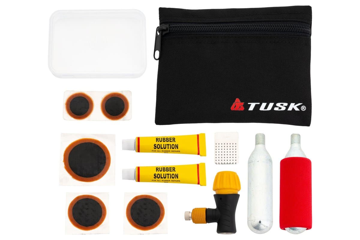 Tusk Tube Repair Kit laid out: patches, rubber cement, scuffer, CO2 chuck and two cartridges beside its pouch and case