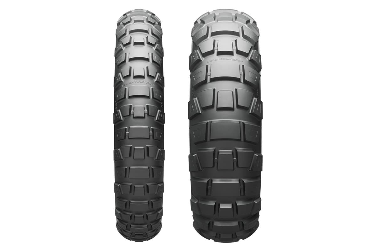 Bridgestone Battlax Adventurecross AX41: front and rear tire side by side, straight-on tread view of the aggressive knob pattern, on white