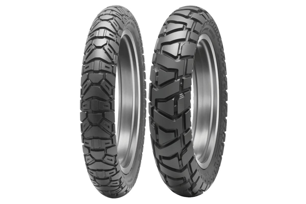 Dunlop Trailmax Mission: front and rear pair side by side on white, the narrow front at left and the wider rear at right, both unmounted with the tread toward the camera