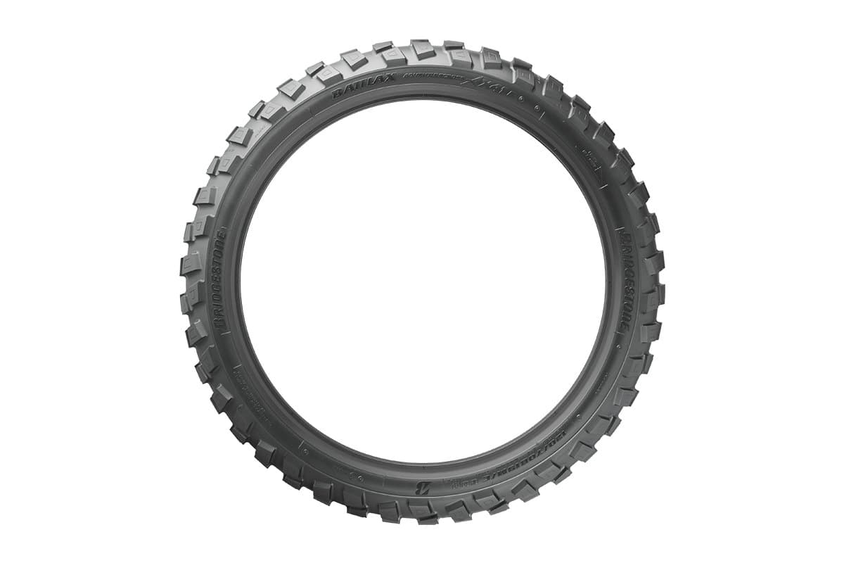 Bridgestone Battlax Adventurecross AX41: the front tire as a full ring seen side on with the knobs in profile, model readable on the sidewall