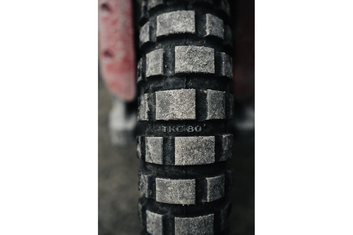 Continental TKC 80 Second Generation: a tight macro of the tread centre on a dusty mounted tire, individual knobs and the moulded model name filling the frame