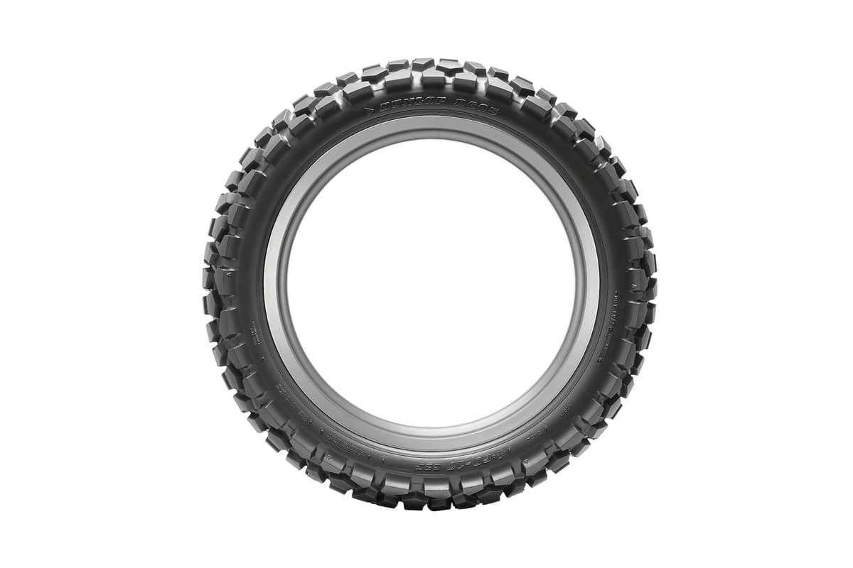 Dunlop D605: rear tire face-on as a full ring on its rim, whole tread circumference and sidewall visible