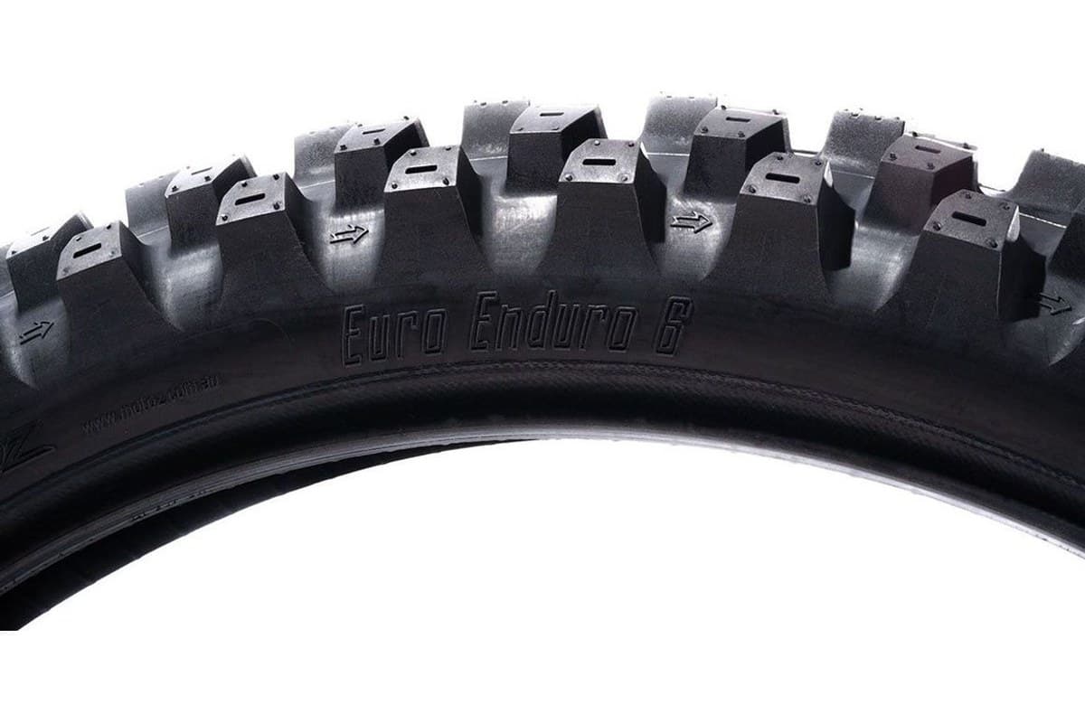 Motoz Euro Enduro 6: the upper arc of the front tire side on, knobs in silhouette, with Euro Enduro 6 moulded into the sidewall