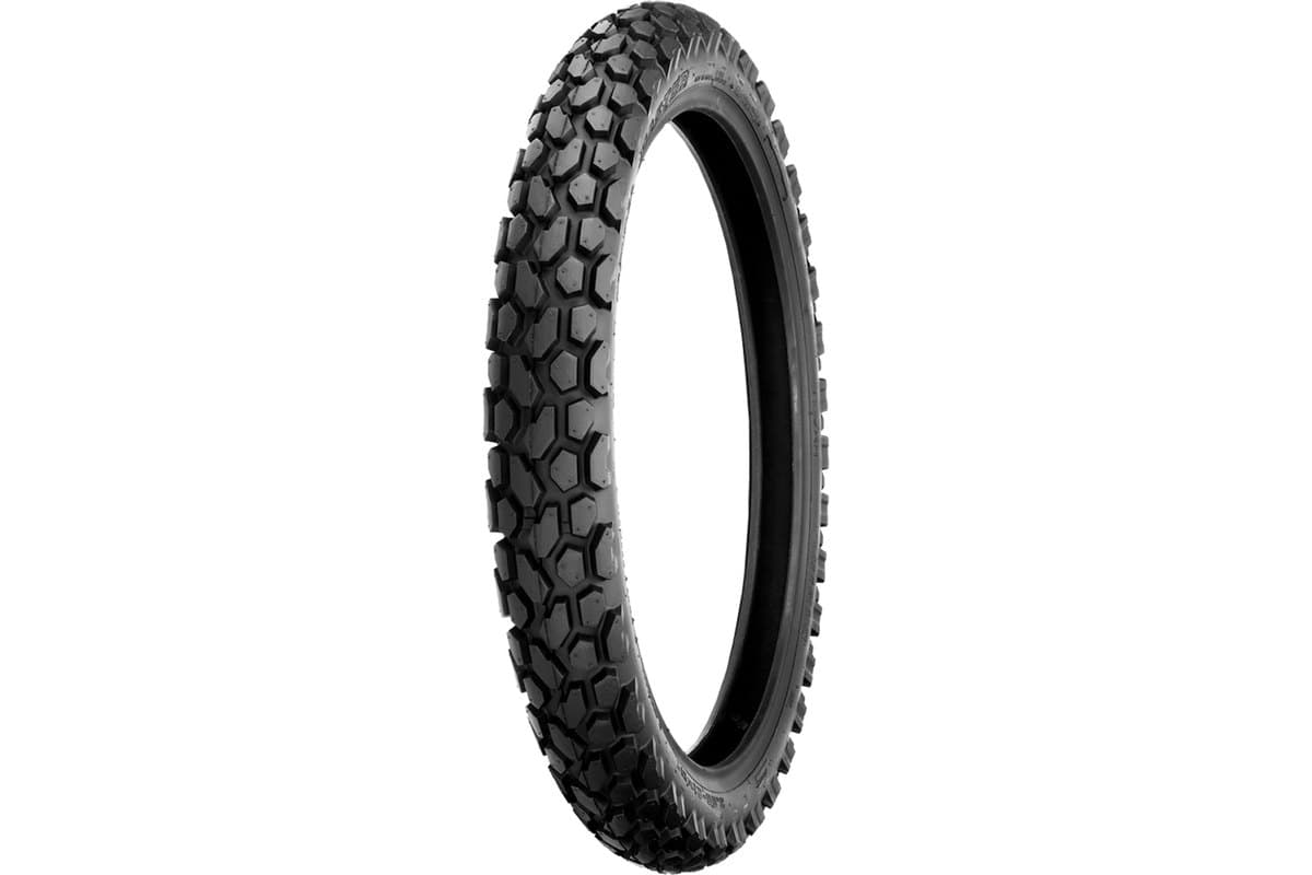 Shinko 700 Series Dual Sport: front tire, three-quarter studio view on white, tall narrow carcass with a dense hexagonal knob pattern