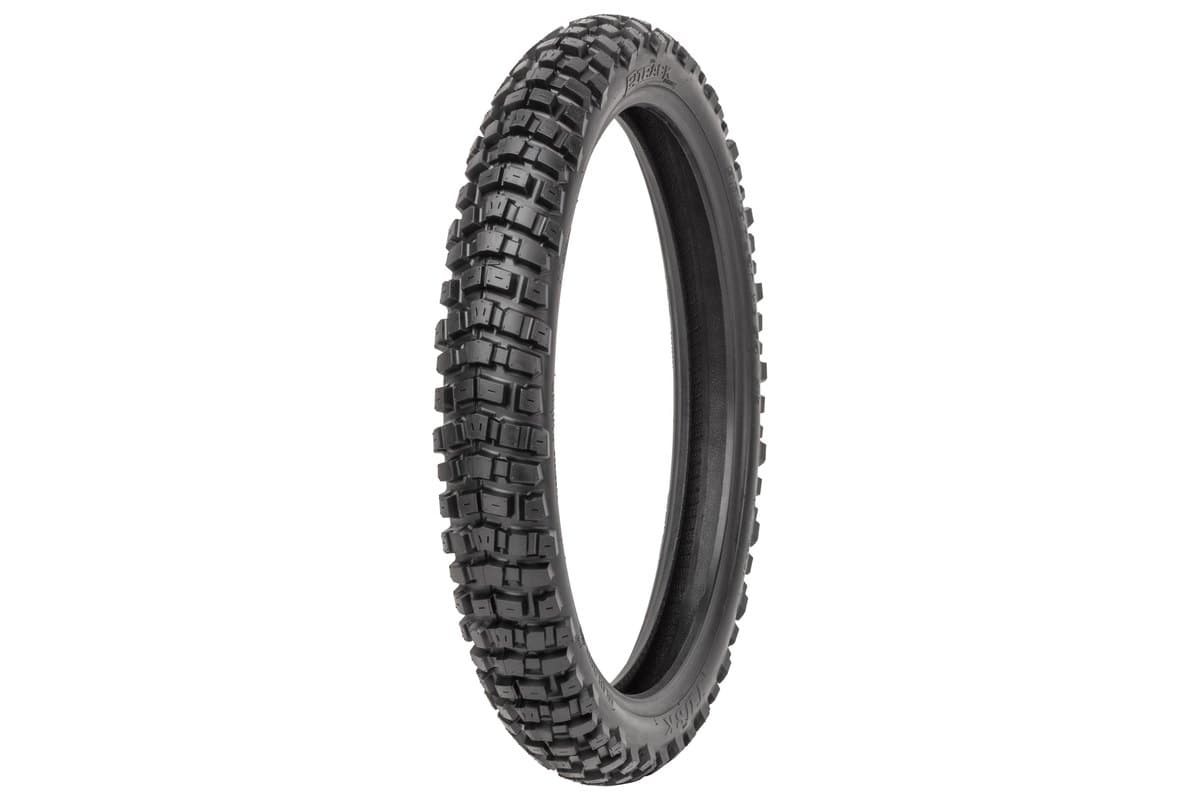Tusk 2Track Adventure: the front tire alone at a three-quarter angle, narrower carcass with small rectangular blocks in staggered rows