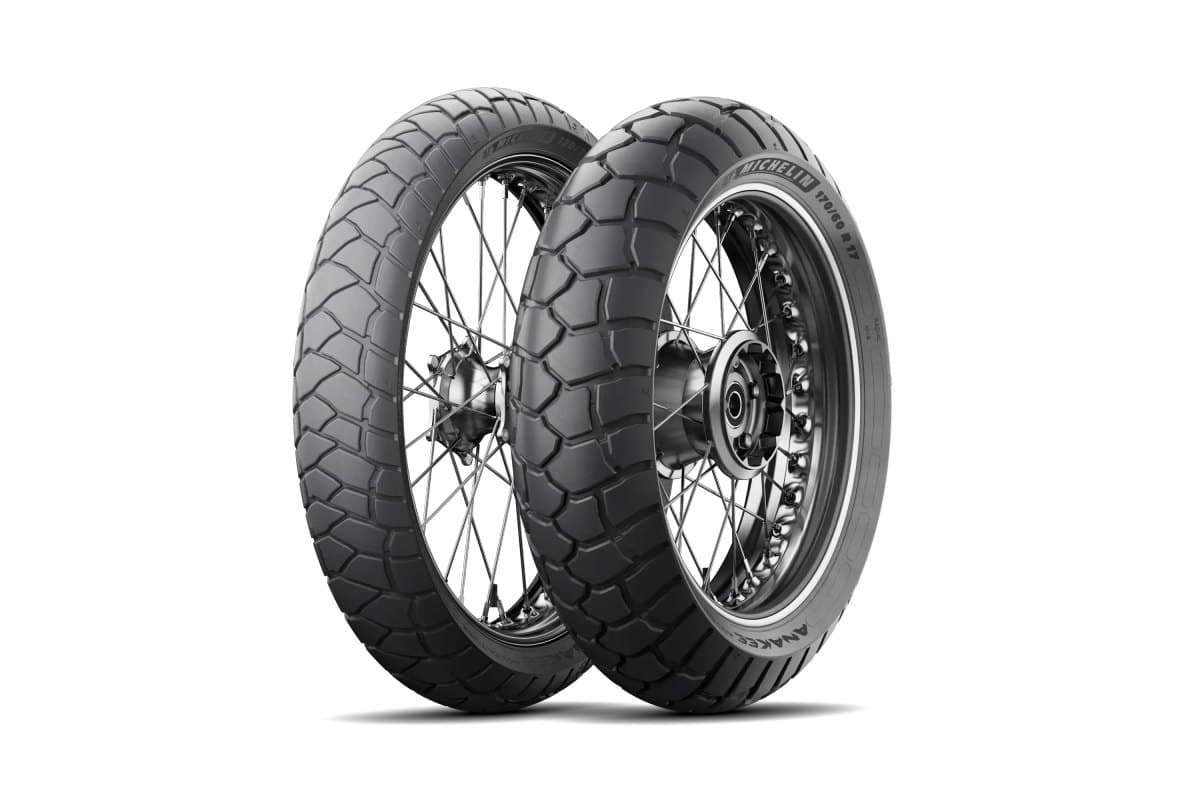 Michelin Anakee Adventure: front and rear pair on silver spoked wheels, three-quarter view, showing the rounded interlocking blocks of the first generation
