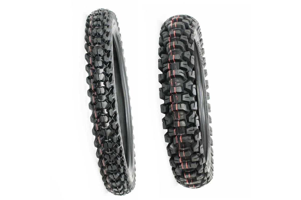 Motoz Tractionator Desert H/T: narrow front tire at left and wide rear at right, both standing, on white