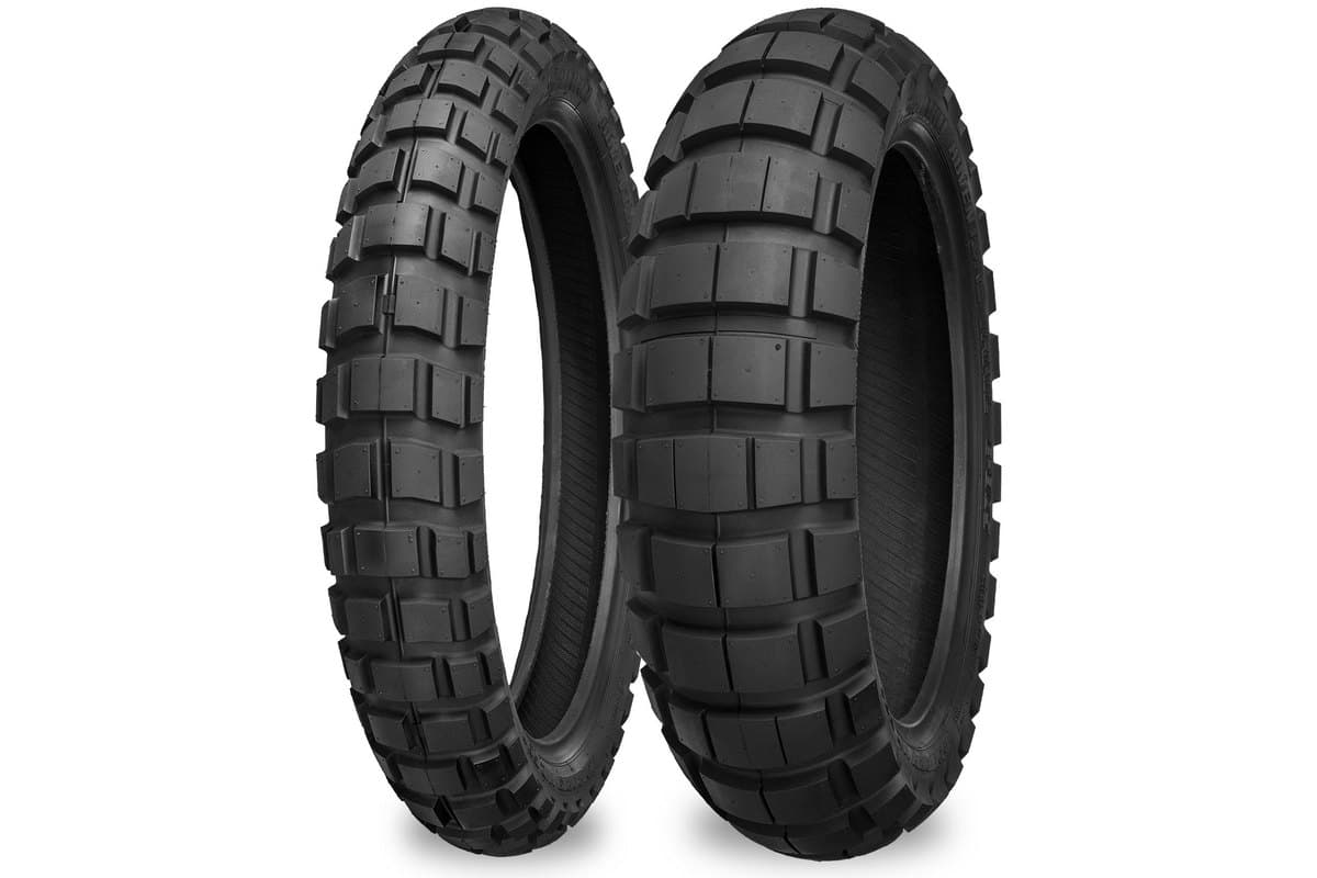 Shinko E804/E805 Adventure Trail: the narrower E804 front at left and the wider E805 rear at right, standing side by side on white with SHINKO ADVENTURE TRAIL moulded into the sidewalls