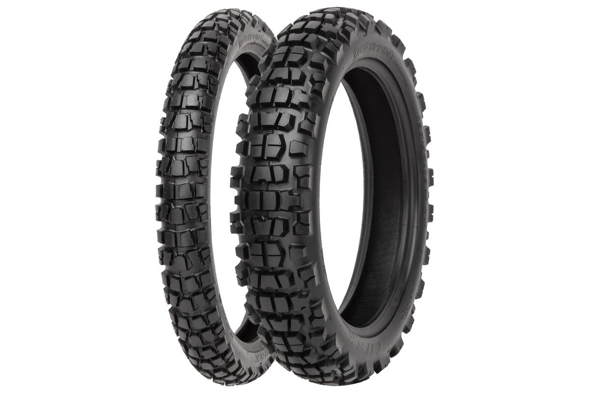 Tusk Waypoint Adventure: front tire in profile behind and rear angled in front, with the model and brand moulded on the sidewalls, on white