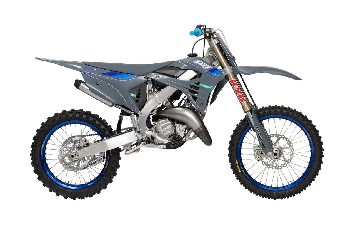 2026 TM MX 125 2T motocross bike in grey with blue graphics, right-side studio profile showing KYB forks, blue rims and twin-pipe exhaust