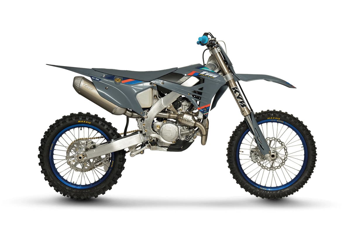 2026 TM MX 300 ES Fi 4T in TM's grey and blue race livery, studio side profile on a white background