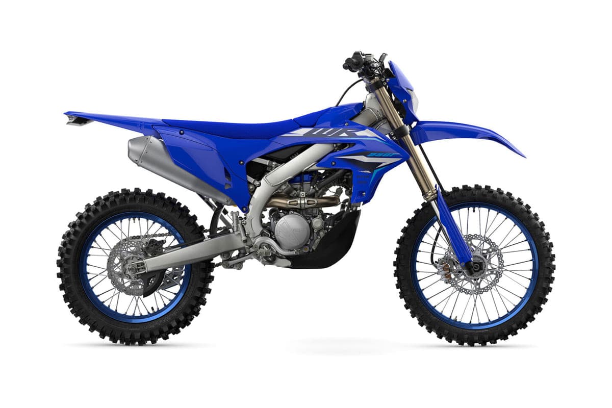 Yamaha WR250F enduro in blue with white number plates, right-side studio profile showing the titanium exhaust, inverted forks and knobby tires