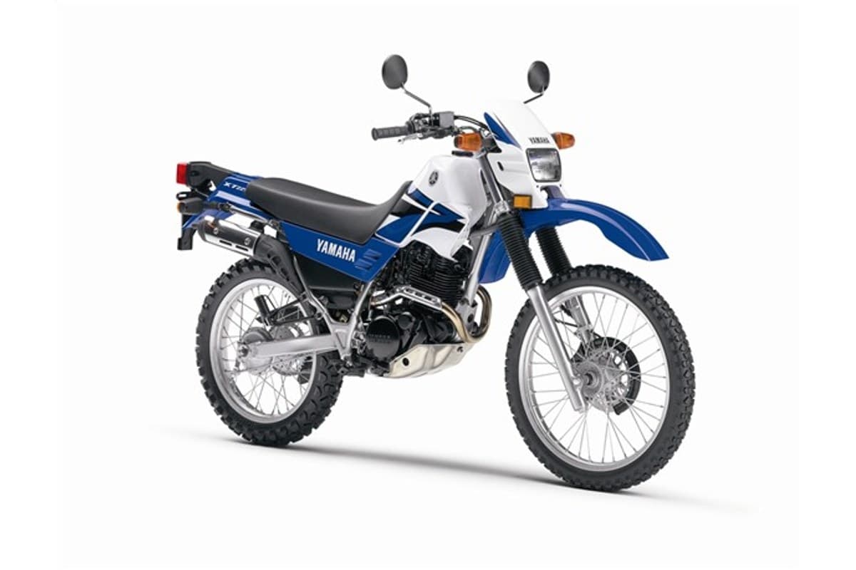 2007 Yamaha XT225 dual-sport motorcycle in white and blue, right-side studio profile showing spoked wheels, twin shocks and small headlight fairing