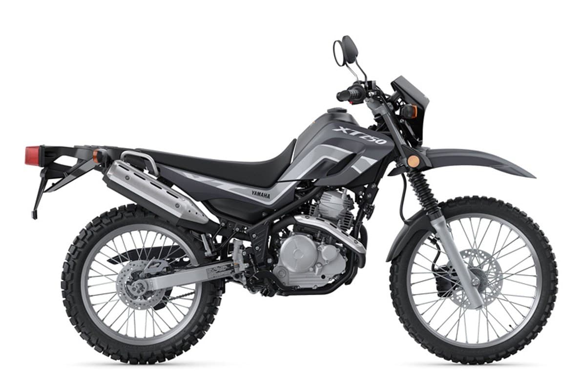 2025 Yamaha XT250 dual-sport motorcycle in black and grey, left-side studio profile showing spoked wheels, upswept exhaust and rear luggage rack