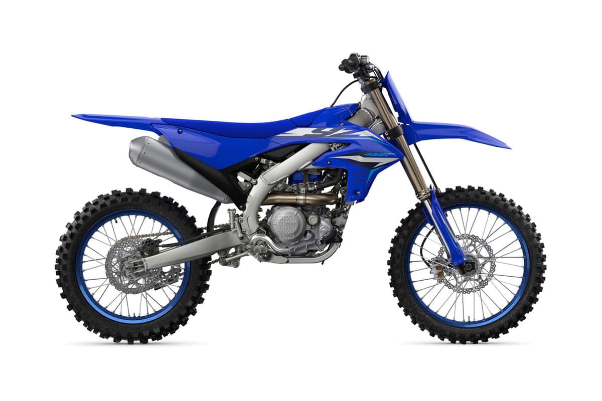 2027 Yamaha YZ450F motocross bike in blue and white, right-side studio profile showing the titanium exhaust and blue-rimmed spoke wheels