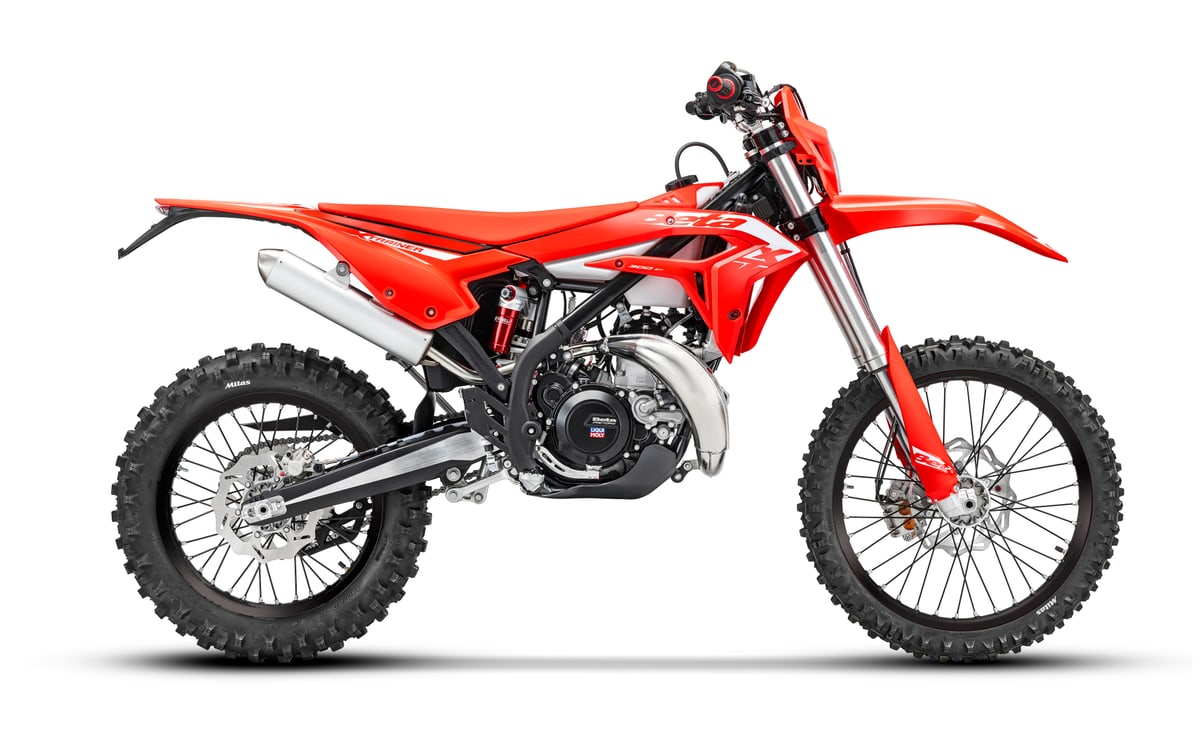 2027 Beta Xtrainer 300 two-stroke enduro in red with black graphics, left-side studio profile showing the chrome silencer and knobby tires