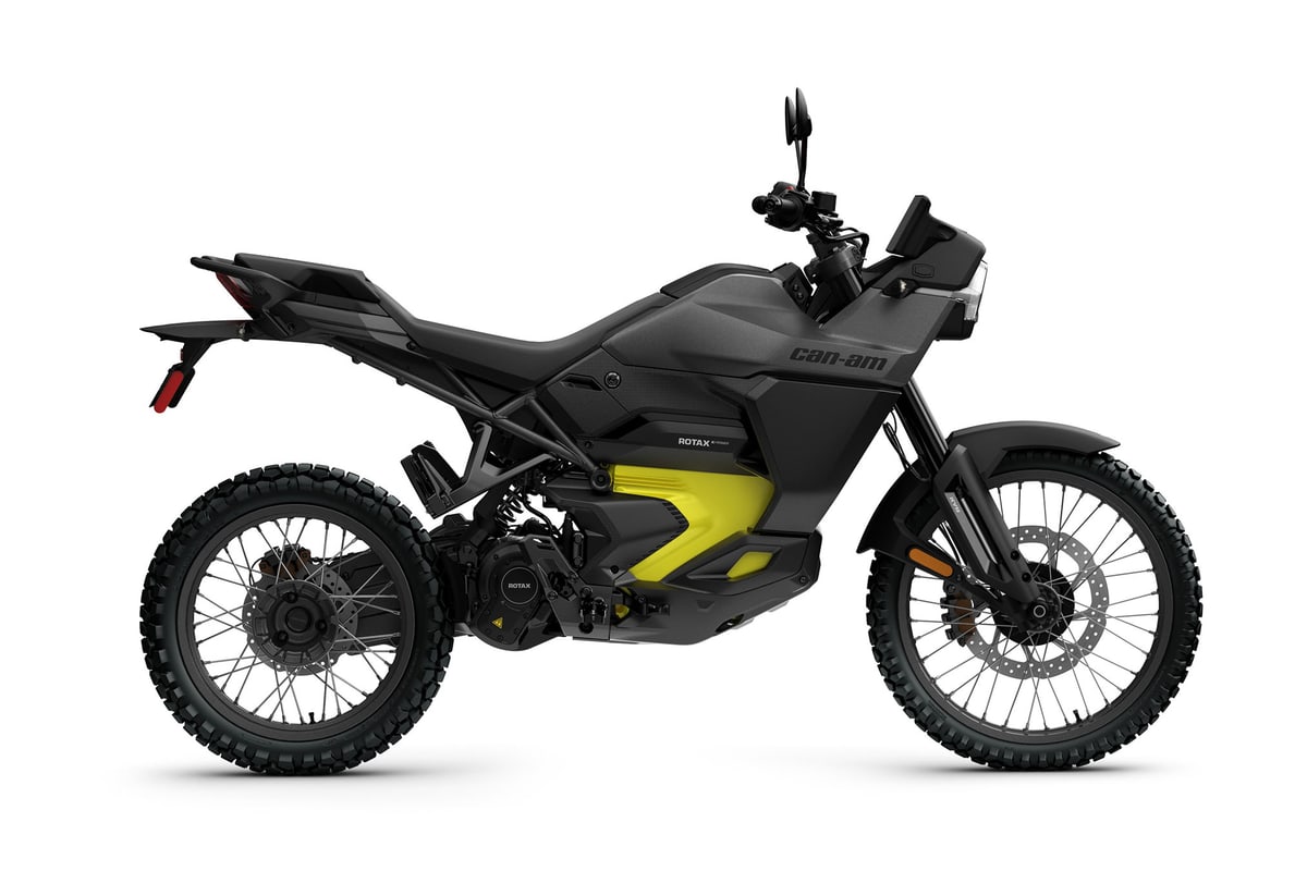 2026 Can-Am Origin electric dual sport in carbon black with yellow accents, left-side studio profile on a white background