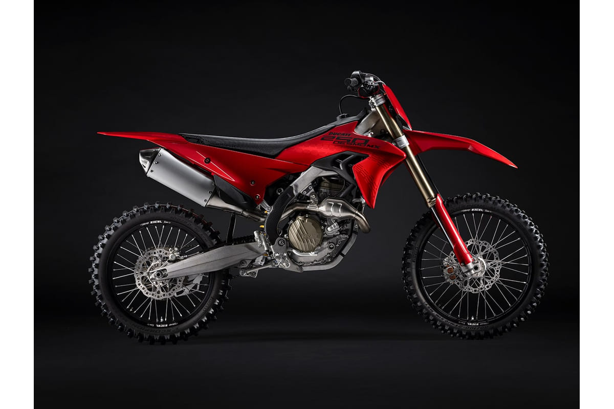 2027 Ducati Desmo250 MX motocross bike in red and black, right-side studio profile showing the exposed trellis-style frame and gold-tone forks