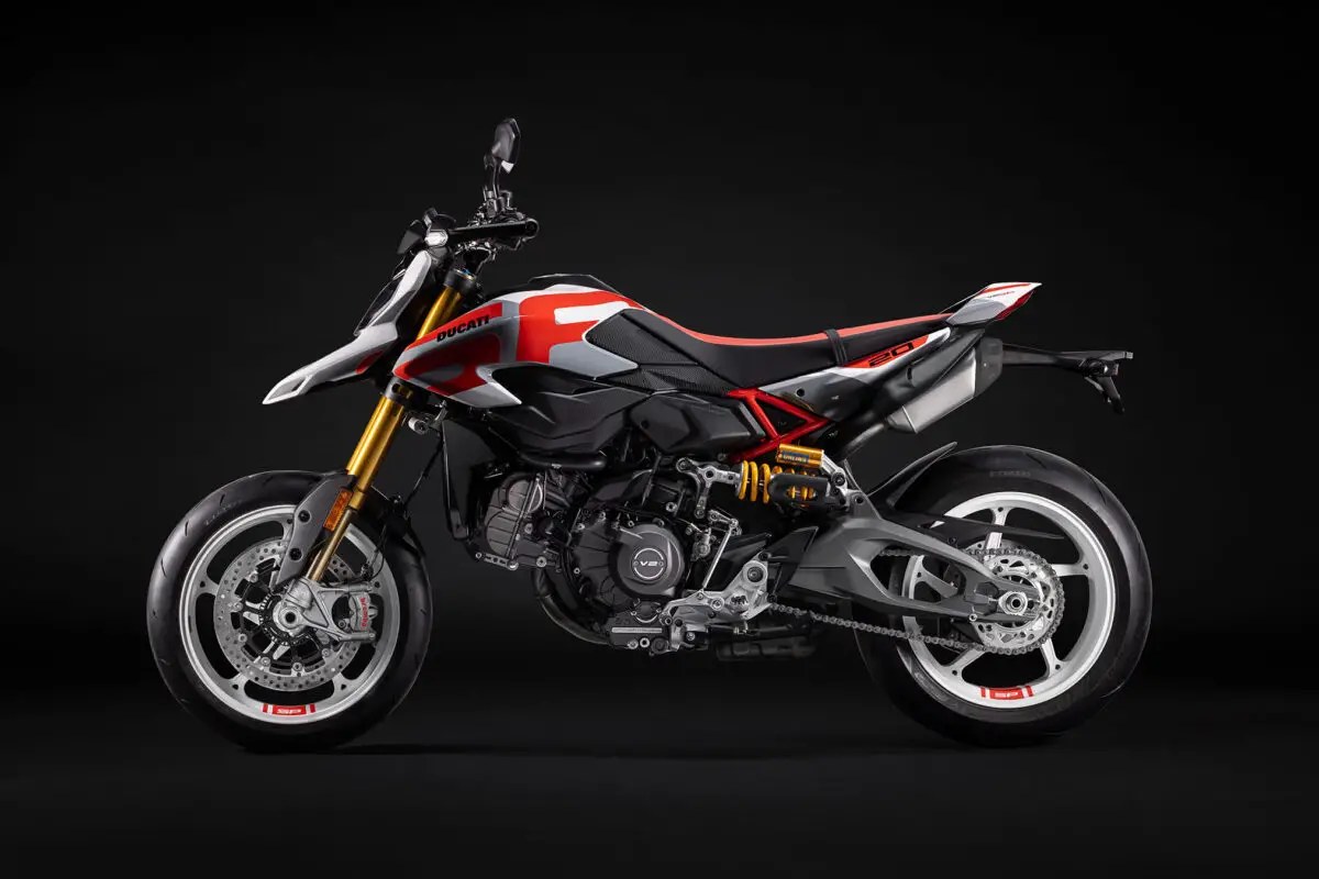 2026 Ducati Hypermotard V2 SP in white and red livery, right-side studio profile showing gold Ohlins forks and twin rear shocks