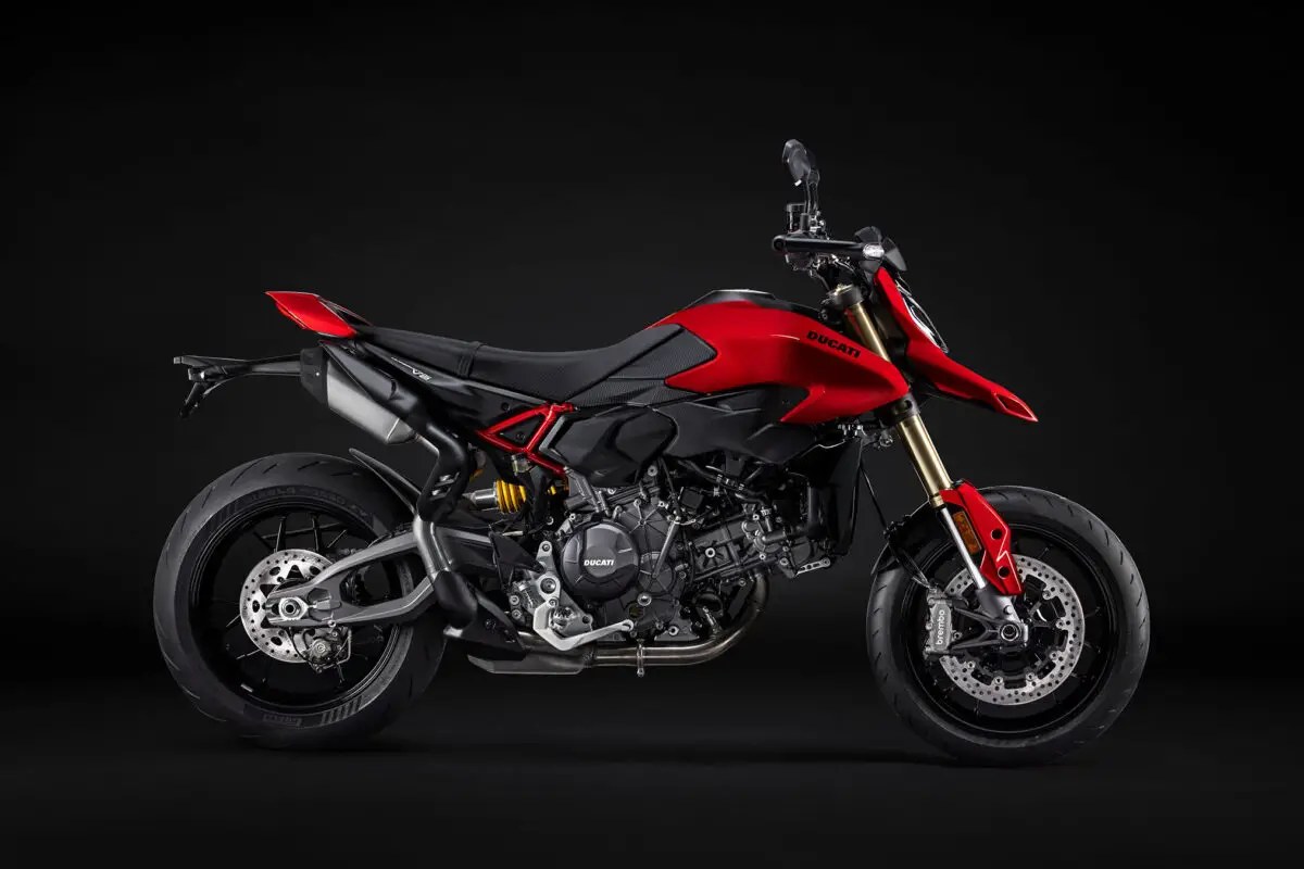2026 Ducati Hypermotard V2 supermoto in red and black, right-side studio profile showing the trellis subframe, gold forks and Brembo front disc