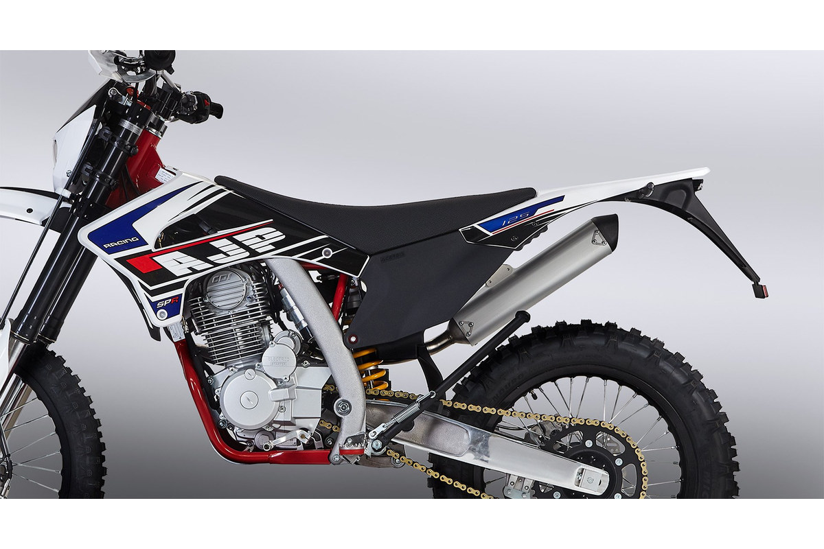 Close-up of the AJP SPR125's left side, showing the air-cooled 124cc engine, seat and aluminium swingarm