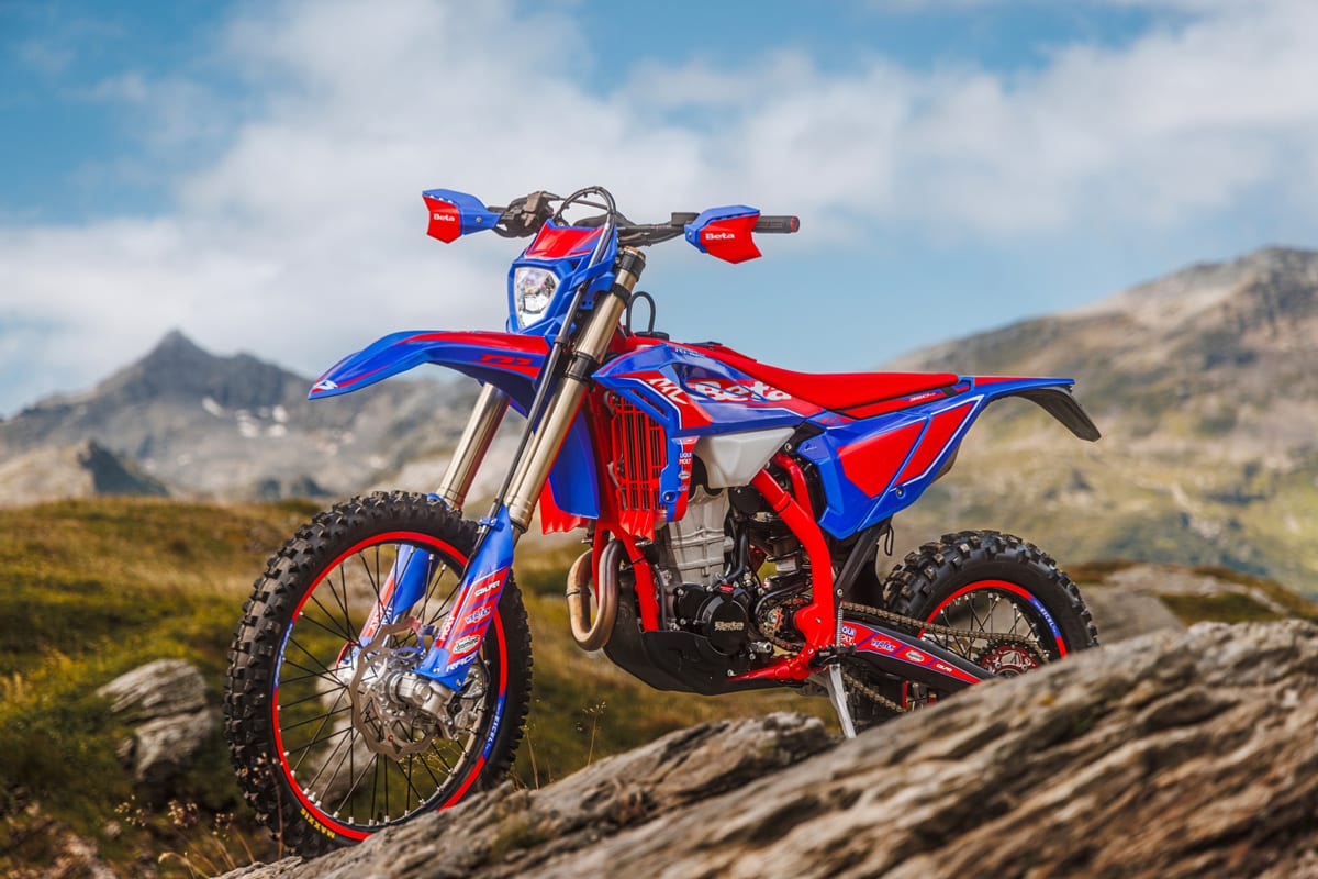 2026 Beta 430 RR Race parked on a rocky mountain outcrop, front three-quarter view against a cloudy alpine sky with handguards and headlight visible