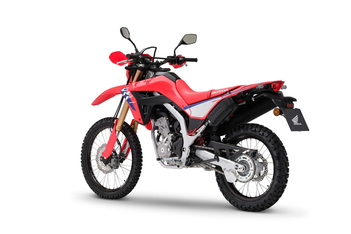 2026 Honda CRF300L in red, front three-quarter studio view showing the round LED headlight, handguards and mirrors