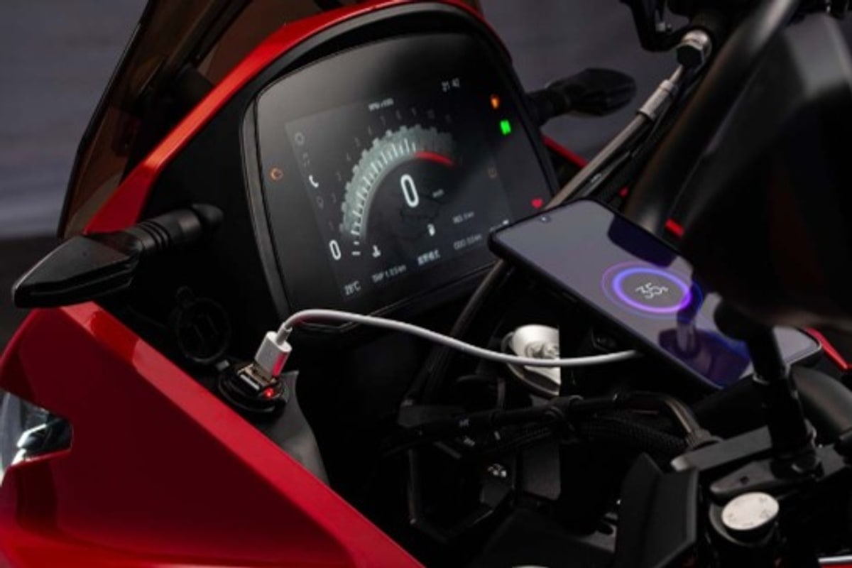 The X-Cape 650's 7-inch TFT display and backlit hand controls, with a phone on the bar-mounted charger