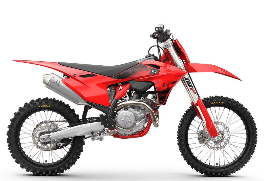2027 GasGas MC 450F motocross bike in red with black shroud graphics, left-side studio profile on a white background showing the muffler and spoked wheels